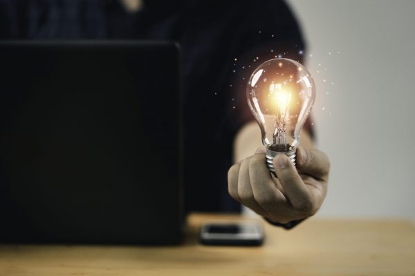 Businessman hand holding lightbulb with glowing light to creative smart thinking for inspiration and innovation with network concept.